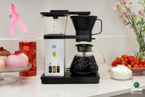 Vinn en kaffemaskin med rosa bandet-motiv hos Opus Bilprovning