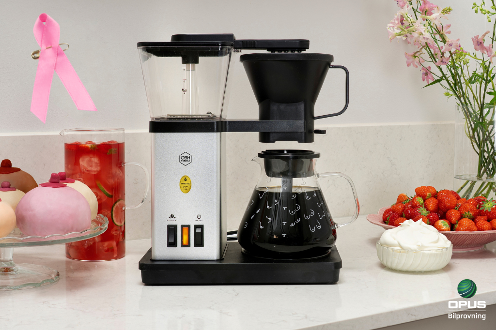 Vinn en kaffemaskin med rosa bandet-motiv hos Opus Bilprovning